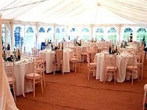 a large white tent with tables and chairs in it at Burcombe Manor in Barford Saint Martin