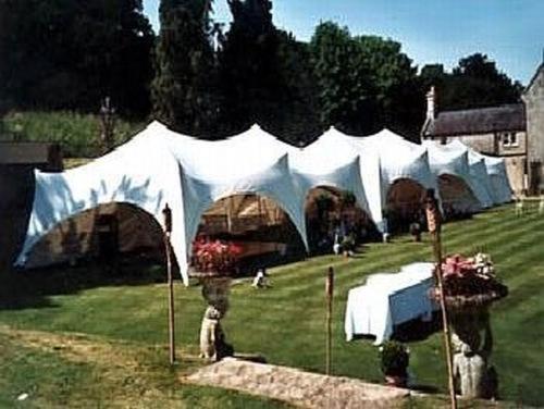 a group of tents in the grass with flowers at Burcombe Manor in Barford Saint Martin