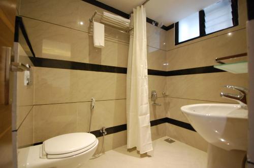 een badkamer met een toilet en een wastafel bij Hotel Ambassador in Indore