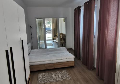 una piccola camera con letto e specchio di Neferprod Apartments - IS - CAM 08 a Timişoara