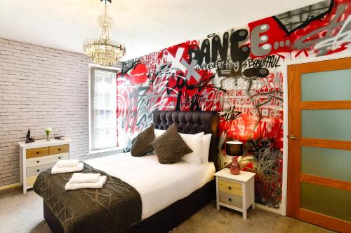a bedroom with a bed and a wall covered in graffiti at Guest Homes - Cambrian Apartment in Swansea