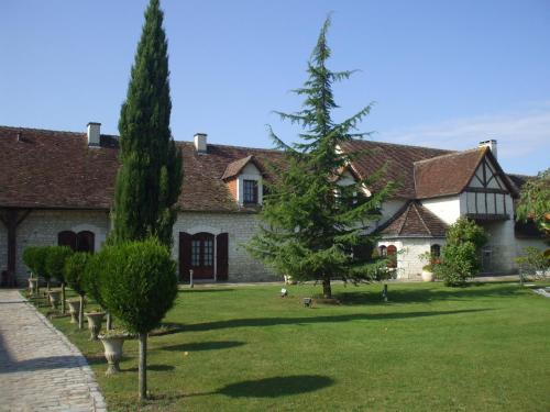 uma casa com árvores em frente a um quintal em Camping Au Clos de Beaulieu em Bossée