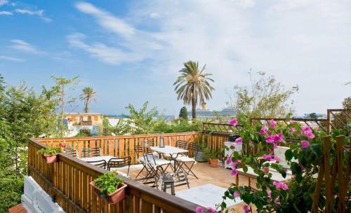 a balcony with tables and chairs and flowers at Kristina´s rooms in Rhodes Town