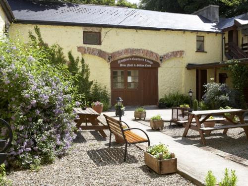 a building with picnic tables and benches in front of it at Carrygerry Country House in Shannon
