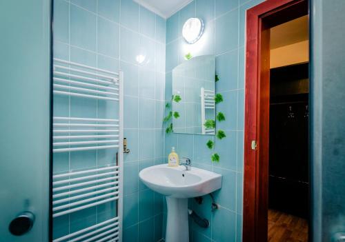 a blue bathroom with a sink and a mirror at Panorama Guesthouse in Sighişoara