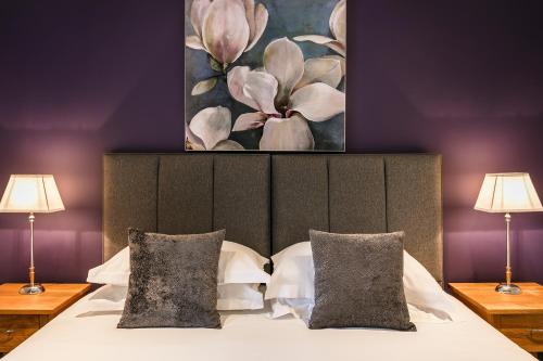 um quarto com uma cama com um quadro na parede em The Lodge @ Carus Green em Kendal