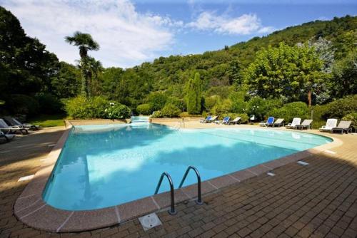 a large blue swimming pool with chairs and trees at St. Maurice smile in Ghiffa