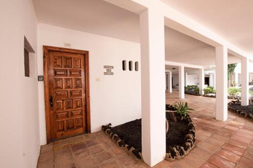 korytarz z drewnianymi drzwiami w domu w obiekcie Lanzahost Casita El Molino w Costa Teguise