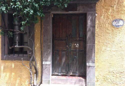 una puerta de madera en el lateral de un edificio en Casa de la Mañana, en San Miguel de Allende