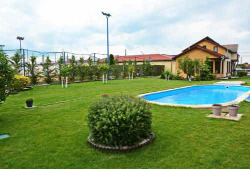 um quintal com uma piscina e uma casa em Neferprod Apartments - IS - CAM 02 em Timisoara