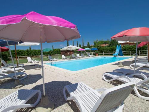 a group of chairs and umbrellas next to a pool at Holiday Home Casa Ponziani by Interhome in Orentano