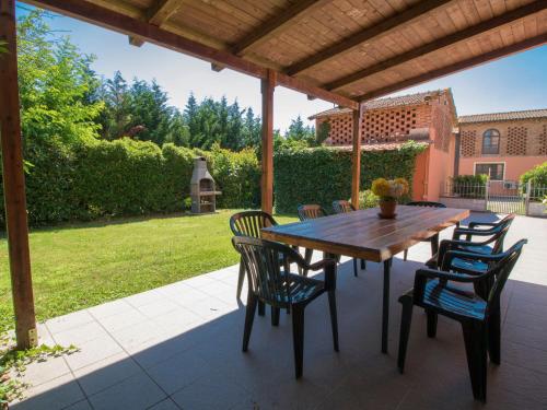 Une table et des chaises en bois sont disponibles sur la terrasse. dans l'établissement Holiday Home Casa Ponziani by Interhome, à Orentano