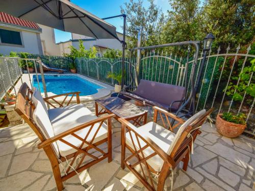 two chairs and a table next to a swimming pool at Apartment Antoine by Interhome in Marina