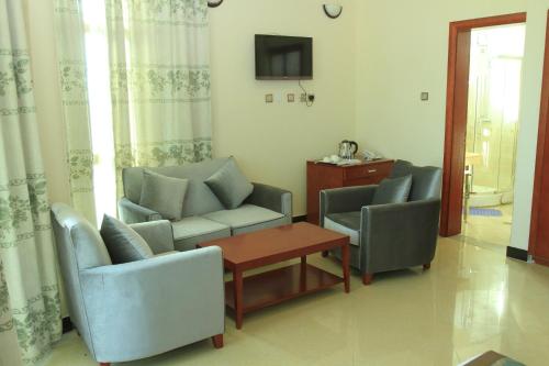 a living room with two chairs and a table at Hera Addis Hotel in Addis Ababa
