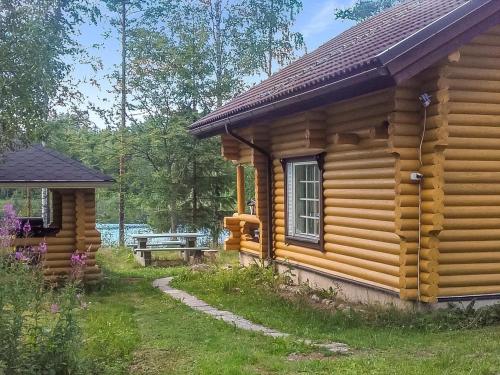 a log cabin with a bench in front of it at Holiday Home Pikku harrila by Interhome in Huuhanaho