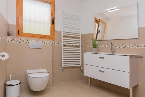 a bathroom with a toilet and a sink and a mirror at Villa Llamedos Montgo Javea by Rock Rentals in Jávea