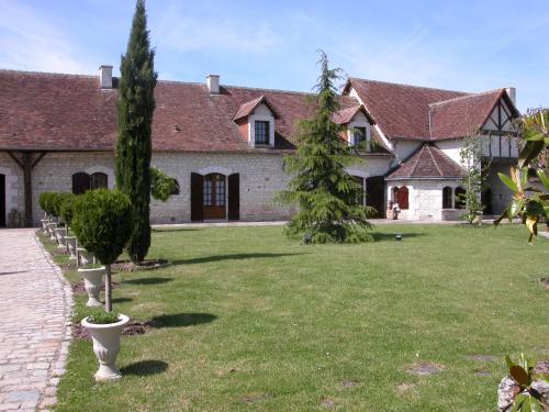a house with a yard with trees in front of it at Chambres d'hôtes Au Clos de Beaulieu in Bossée