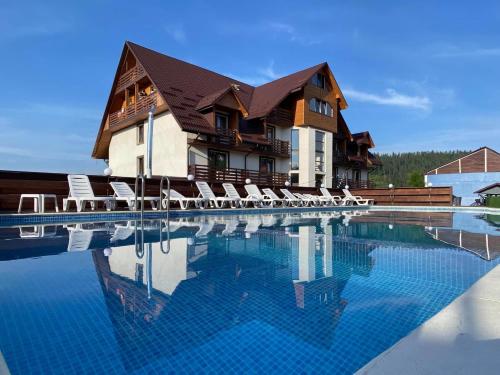 a house with a swimming pool with lounge chairs at Готель Поляницький in Bukovel