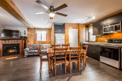- une cuisine et une salle à manger avec une table et des chaises dans l'établissement Le Chalet Relax du Lac St-Tite, à Saint-Tite-des-Caps