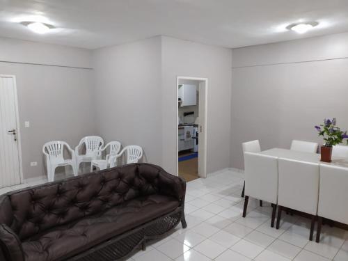 a living room with a couch and a table and chairs at Apartamento na Praia da Enseada in Guarujá