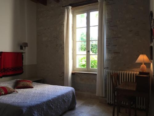um quarto com uma cama e uma janela em Les Huguets em Villeneuve-sur-Lot