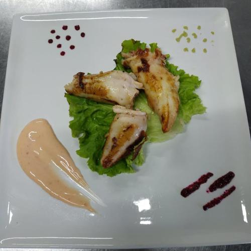 a plate of food with chicken lettuce and sauce at Sunrise Hotel Orikum in Orikum