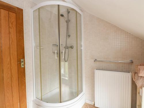 a shower with a glass door in a bathroom at Moody House Farm in Chorley