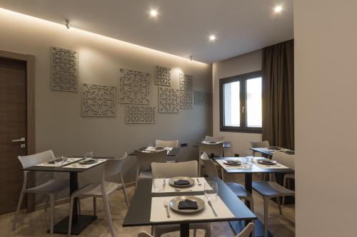 a restaurant with tables and chairs and a window at Giafra Luxury Rooms in Agrigento