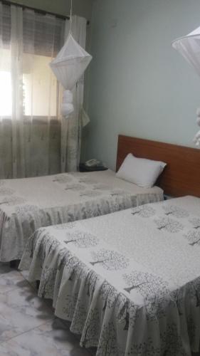Una cama o camas en una habitación de Sunset International Hotel