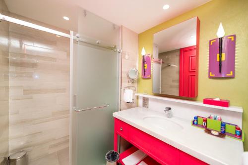 a bathroom with a sink and a shower and a mirror at The Land Of Legends Kingdom Hotel - All-in Concept in Belek
