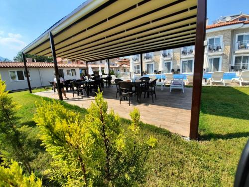 a wooden deck with tables and chairs in a yard at Vespera hotel in Dalyan