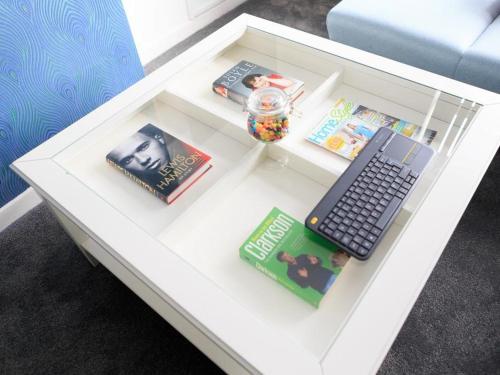 a white coffee table with a keyboard and books on it at Live in Leeds Grange Apartments in Leeds