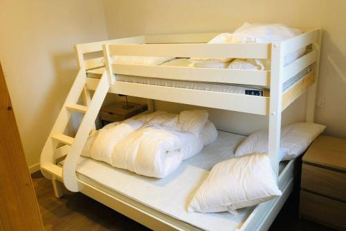 a white bunk bed with four pillows on it at Alta in Valloire