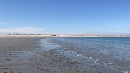 a beach with the tide out and the ocean at Hotel K in Bahia Inglesa