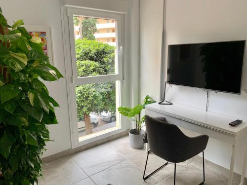 Zimmer mit einem Schreibtisch, einem TV und einer Anlage in der Unterkunft Neptuno Beachfront Apartments in Marbella