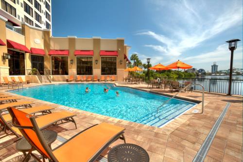 a pool at a hotel with chairs and people in it at Plaza Suites On International Drive Near Universal Epic in Orlando