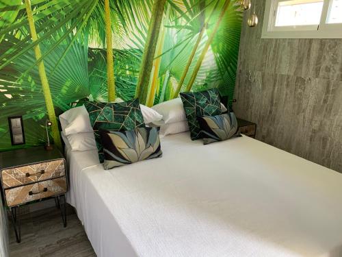 マルベーリャにあるNeptuno Beachfront Apartmentsの緑の植物が植わる大きなベッド付きのベッドルーム1室