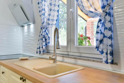 eine Küche mit einem Waschbecken und einem Fenster in der Unterkunft Apartments Crno in Zadar