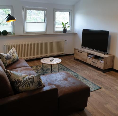 a living room with a couch and a flat screen tv at Rheingold in Hirzenach