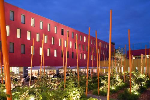 a large red building with trees in front of it at Radisson Blu Hotel Toulouse Airport in Blagnac