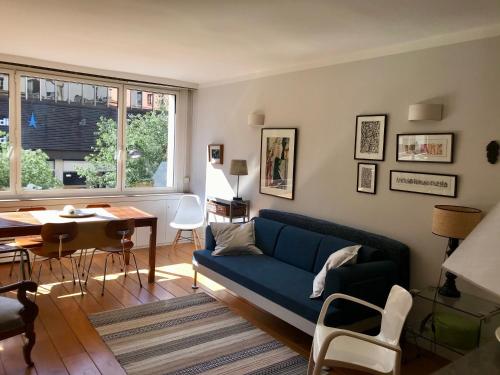 a living room with a blue couch and a table at Standing-Montparnasse in Paris