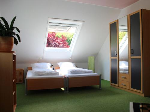 a bedroom with two beds and a window at Ferienwohnung auf der Baar in Bad Dürrheim