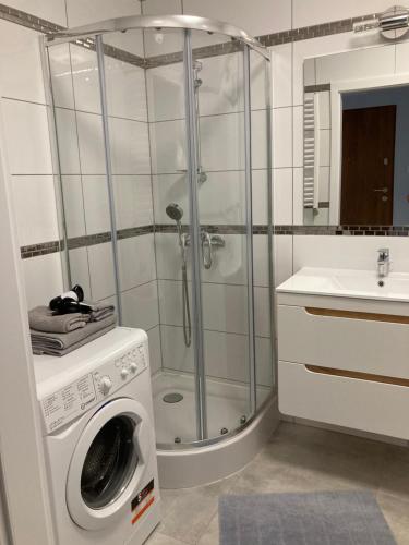 un bagno con doccia e lavatrice di Apartament al. Solidarności a Białystok