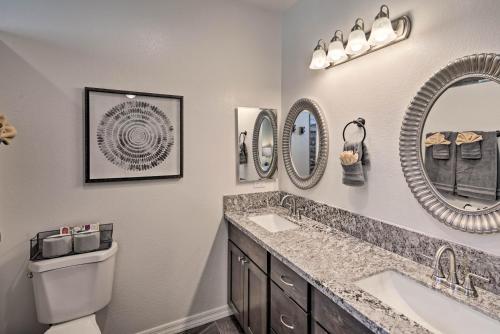 a bathroom with two sinks and two mirrors at Luxe Home with OHV Access, 5 Mi to Lake Mohave! in Bullhead City