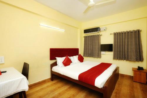 a hotel room with a bed with red and white sheets at Hotel Green Plaza in Trichūr