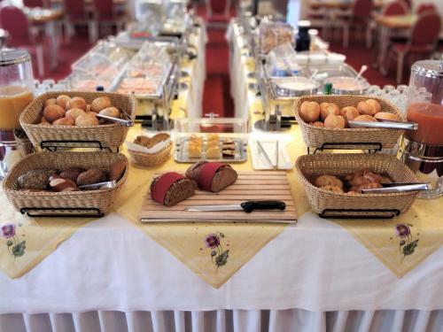 uma mesa com cestas de pão e outros alimentos em Hotel Scholz em Koblenz