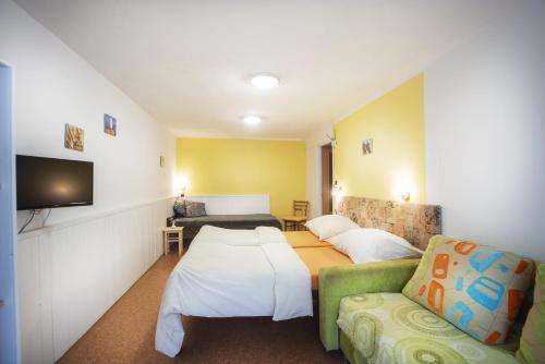 a hotel room with two beds and a couch at Penzion Mašek in Cheb