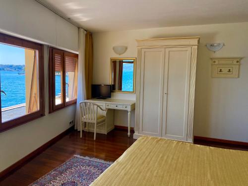a room with a desk and a computer with a window at Camere Al Veliero in Gardone Riviera