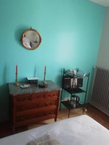 a bedroom with a blue wall with a dresser and a mirror at La Maison d'Alienor in Saint-Médard-de-Guizières