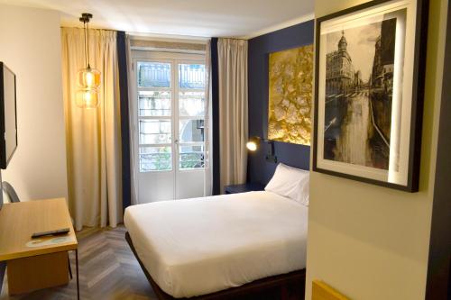 a hotel room with a bed and a window at Alda Galería Coruña in A Coruña